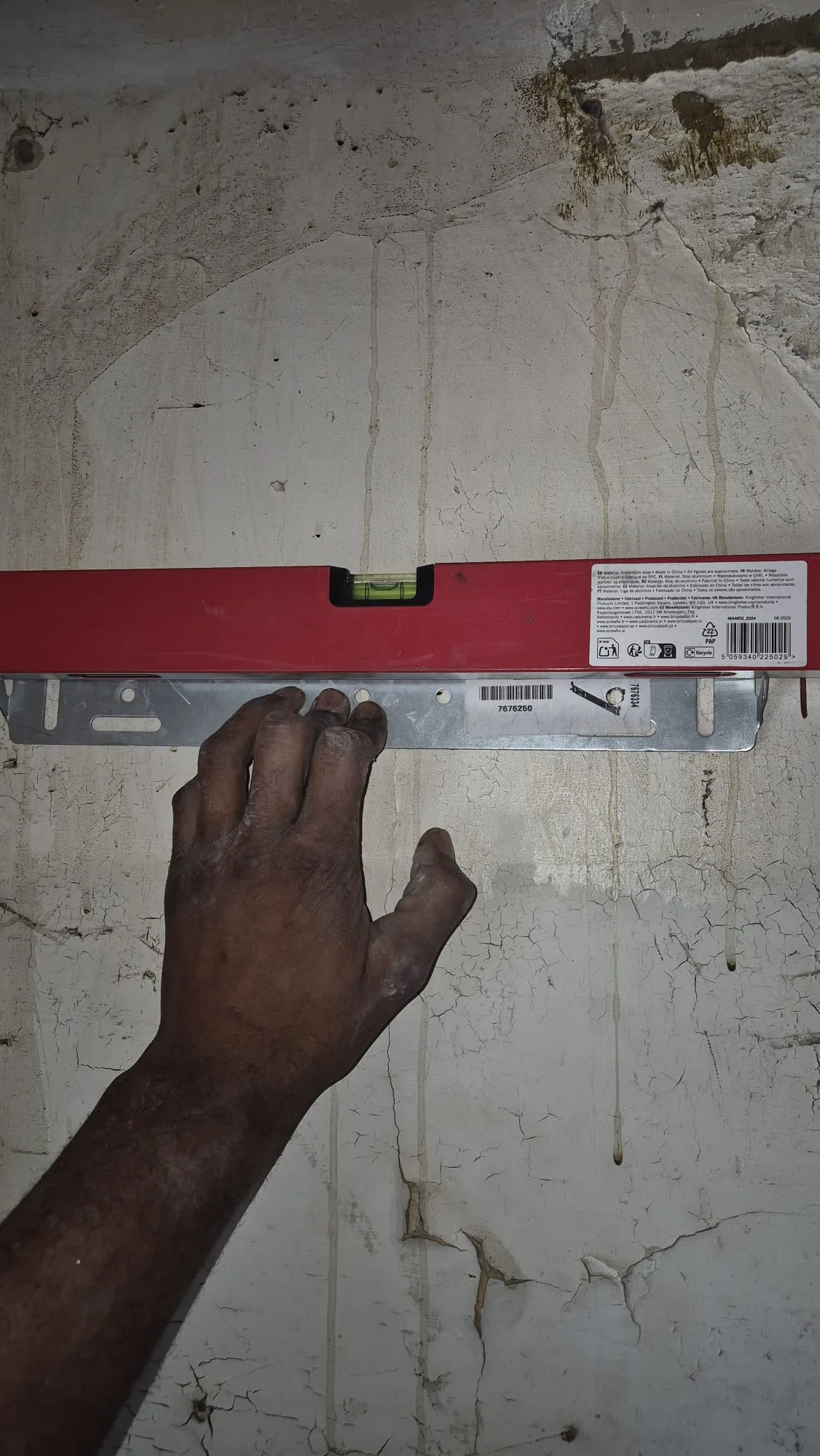 Setting out the new boiler bracket — checked with a level before a single hole is drilled.