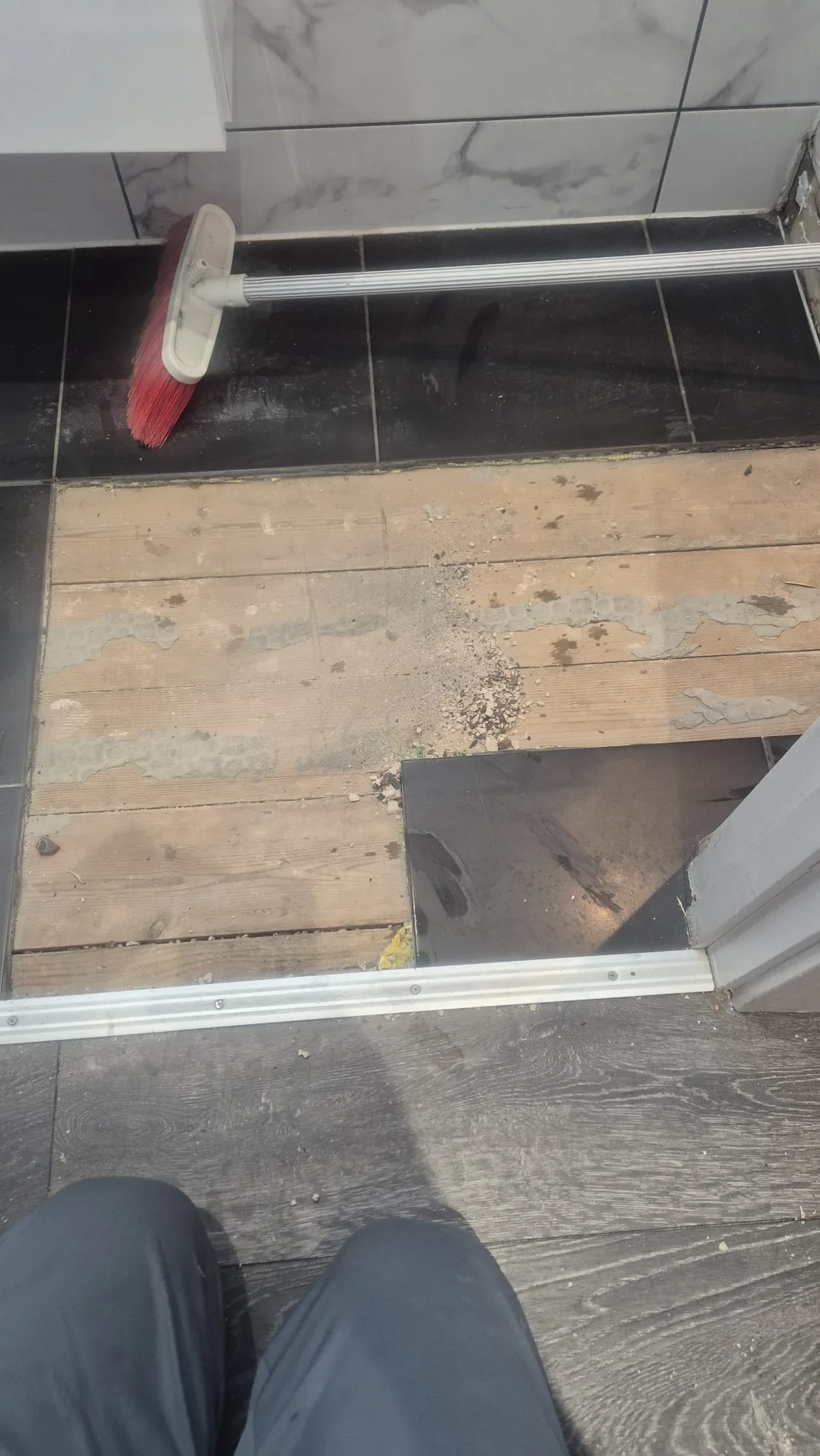 Tiles lifted and floorboards exposed to get at the pipework beneath.