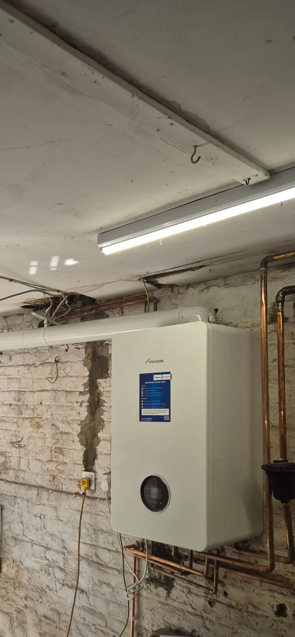 Wider angle showing the horizontal flue run along the wall alongside the risers and filter.