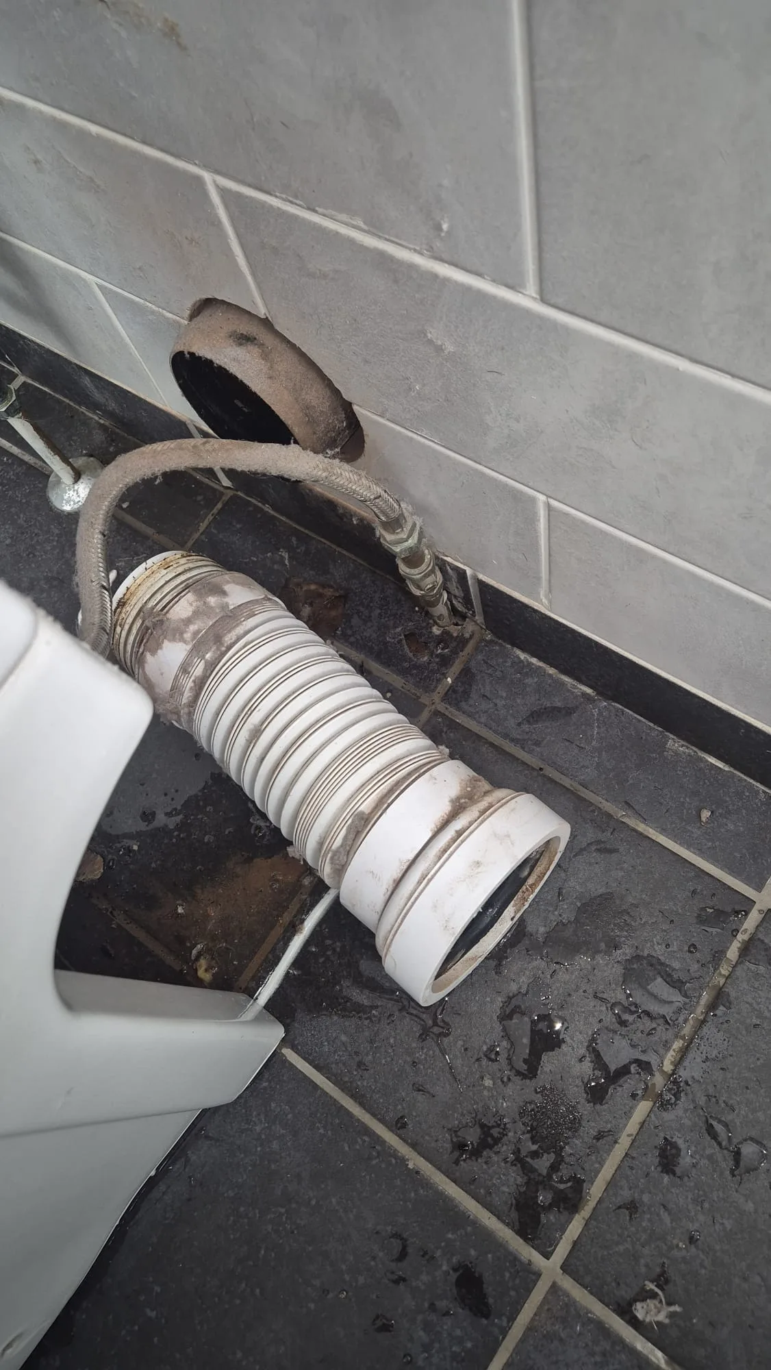Pan connector disconnected from a rusted soil pipe socket, with the failed flexi and isolator alongside.