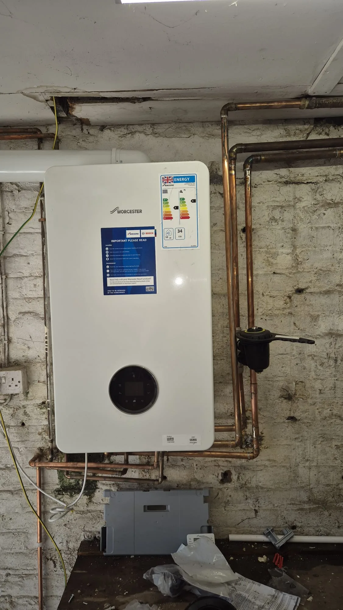 Finished. The energy label reads 34kW and A-rated, there is a magnetic filter on the return, and the copper is run square.